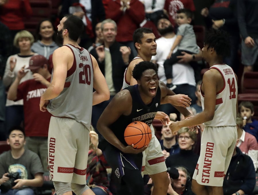 Washington’s Noah Dickerson, center with ball, celebrates after the defeat of Stanford at the end of an NCAA college basketball game Sunday, March 3, 2019, in Stanford, Calif.