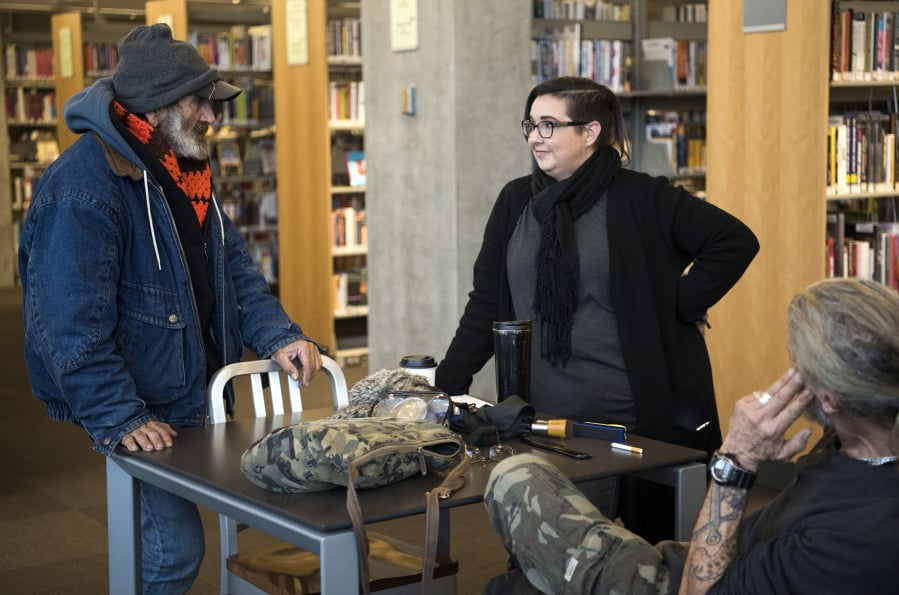 Jack Crowley, left, chats with Jamie Spinelli, a case worker with Community Services Northwest, on Dec. 11 in the Vancouver Community Library. Crowley had been homeless for about 34 years but recently got housing. As part of a pilot project, Spinelli works in the library to help connect homeless people with resources.
