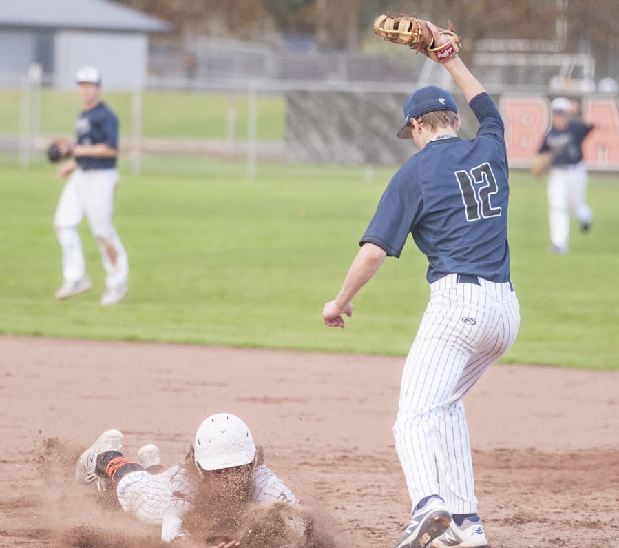 Skyview’s Titus Oien stretches out to record a game-ending double play as Battle Ground’s Sean Pearce slides back into first base in a 4A Greater St. Helens League baseball game Thursday in Battle Ground. Skyview won 12-2.