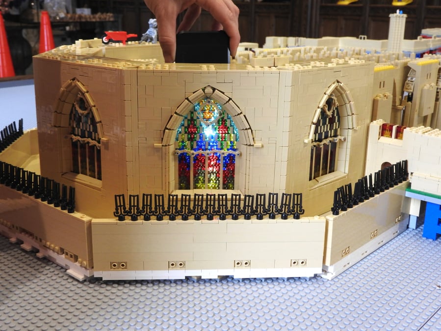 Washington National Cathedral is raising money for repairs from a 2011 earthquake by having visitors build a Lego model of the cathedral. The light from a cellphone shows off a stained glass window in Bethlehem Chapel.