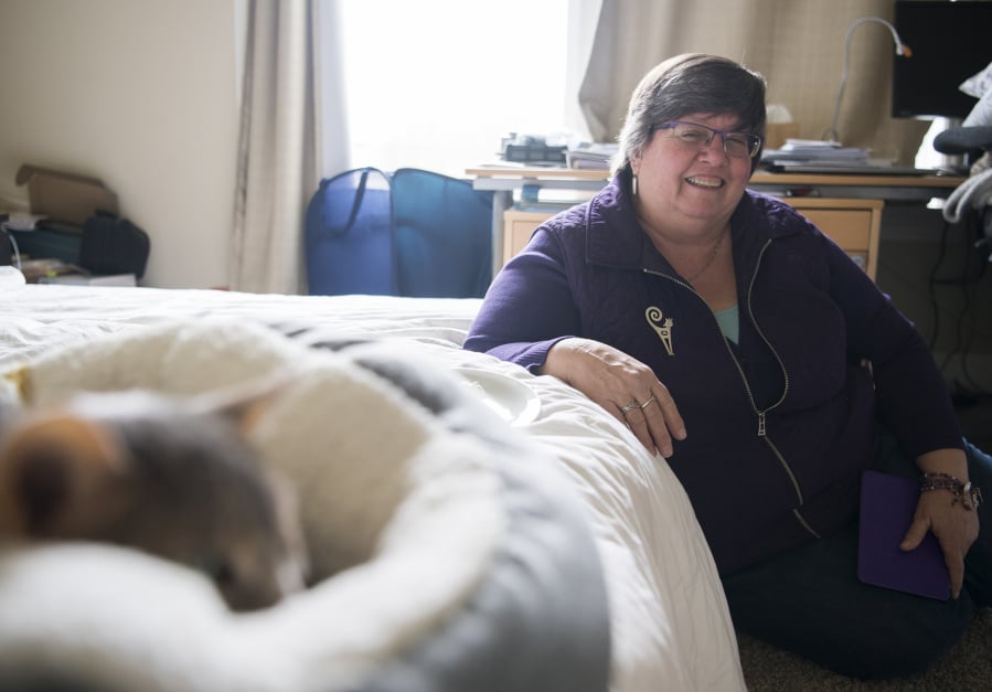 Patt Doyle, owner of Pampurred Pet Care, sits with the cat Posha during a house visit. She’s been watching the cat for a few years, Doyle said. She doesn’t agree with people who believe that cats are independent and don’t need much tending to. ‘A lot of people say that but cats are predators and they tend to hide their illnesses. And, they are pets, they are used to us being around,’ she said.