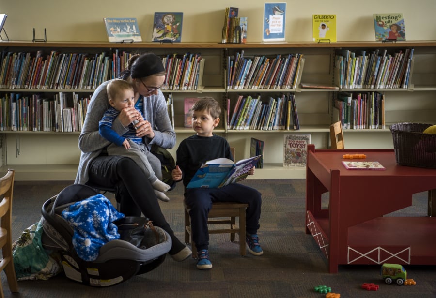 Katie Didyk of Battle Ground holds her son Benny, 9 months, and reads with her son Artem, 4, at the Battle Ground Community Library, which will close for three weeks starting Monday for upgrades, one of which is rearranging furniture to make the children’s area more comfortable for families. While Battle Ground will have some minor upgrades, Fort Vancouver Regional Libraries is also in the process of trying to build four new buildings to increase services around the county.