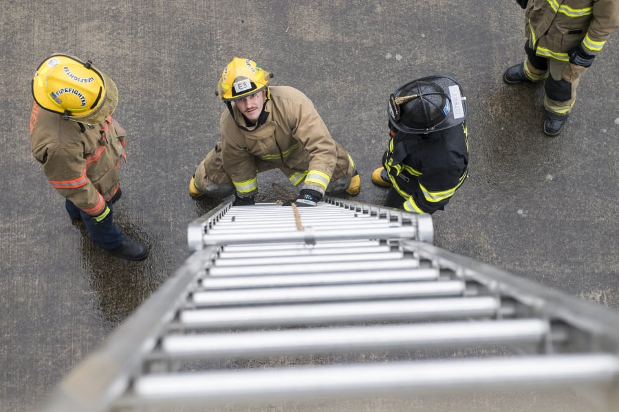 Instructor Graham Lasee, from left, observes as recruits Bryson Lemire and Aaron Cliburn practice raising a ladder during training at Camas-Washougal Fire Station 42 on Wednesday afternoon.
