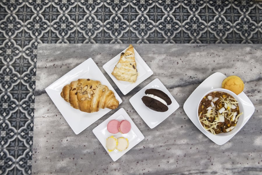 An almond croissant, from left to right, a cranberry orange scone, macaroons, a Classic Whoopee Pie, and chili con carne with a corn bread muffin at Chandelier Bakery.