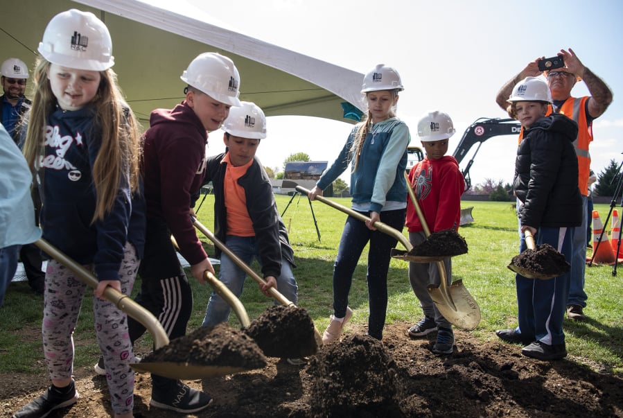 Students from Sifton Elementary School break ground Wednesday on the site of a future elementary school campus during a school assembly in Vancouver.