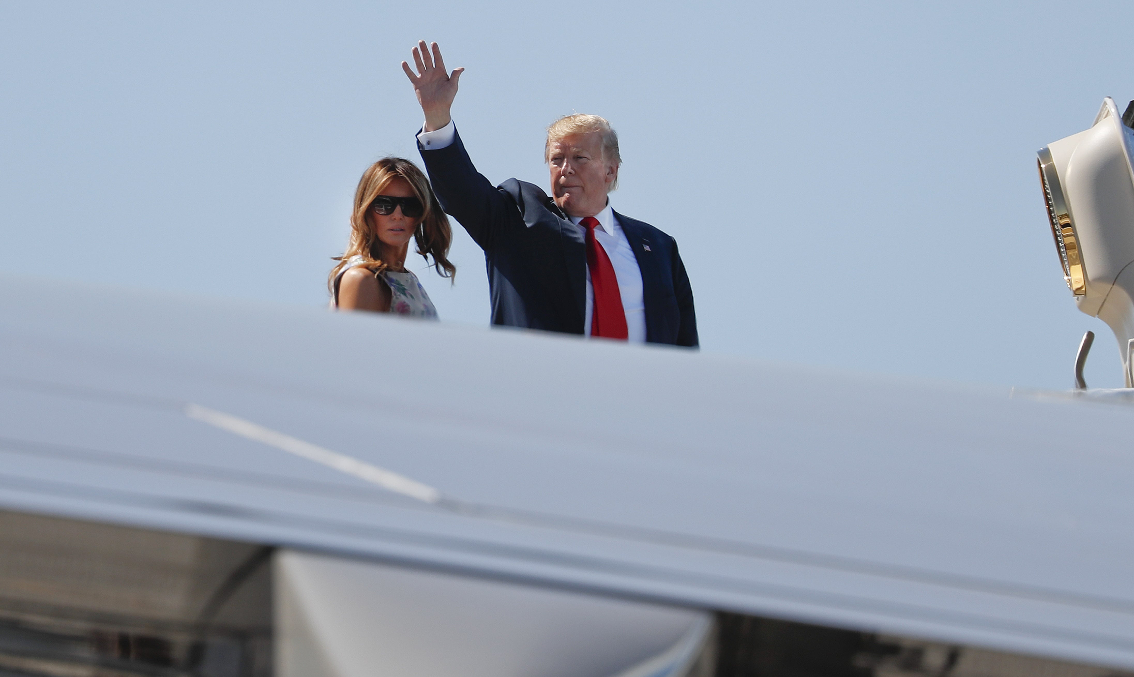 President Donald Trump, right, waves as he and first lady Melania Trump board Air Force One prior to departure from Palm Beach International Airport, Sunday, April 21, 2019, in West Palm Beach Fla.