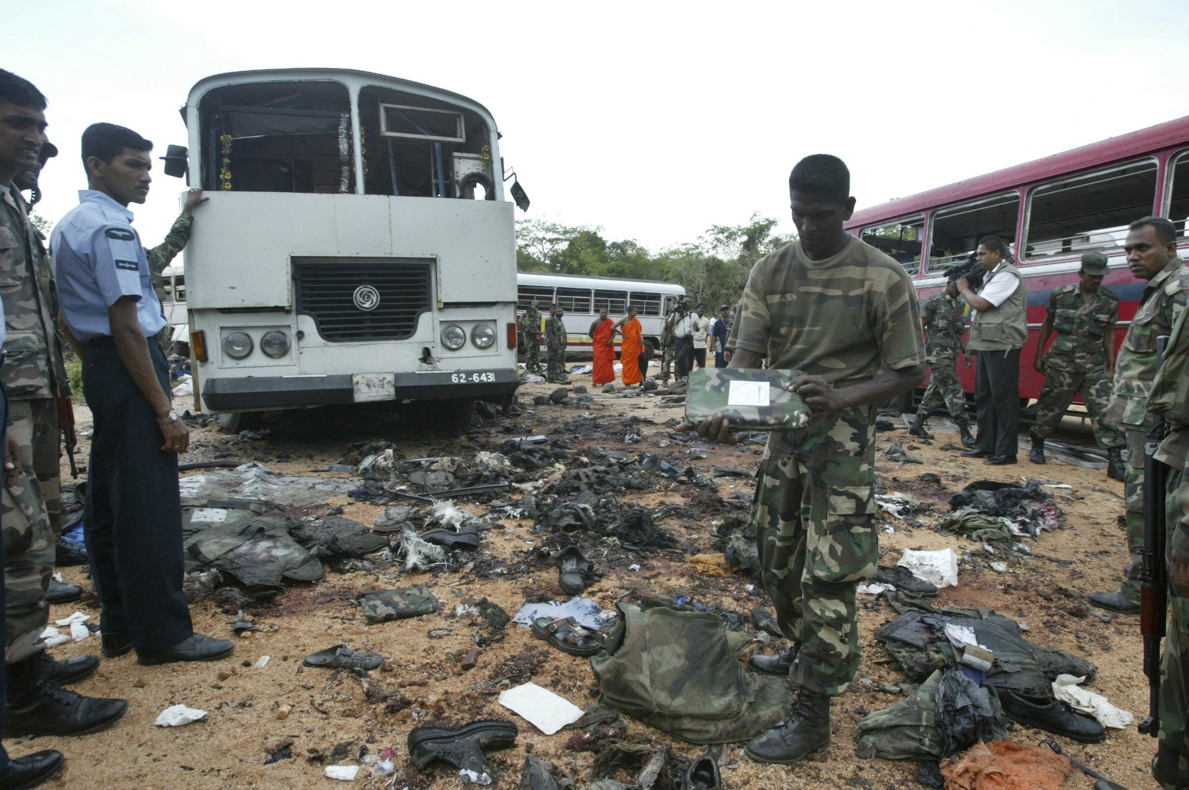 FILE - In this Oct. 16, 2006, file photo, a Sri Lankan soldier inspects the debris at the site of a suicide explosion by Tamil Tigers near Dambulla, about 150 kilometers (90 miles) northeast of Colombo, Sri Lanka. The April 21, 2019 deadly Easter attacks in Sri Lanka are a bloody echo of decades past in the South Asian island nation, when militants inspired by attacks in the Lebanese civil war helped develop the suicide bomb vest. Over nearly 30 years of civil war, the Tamil Tigers would launch more than 130 suicide bomb attacks, making them the leading militant group in such assaults at the time.