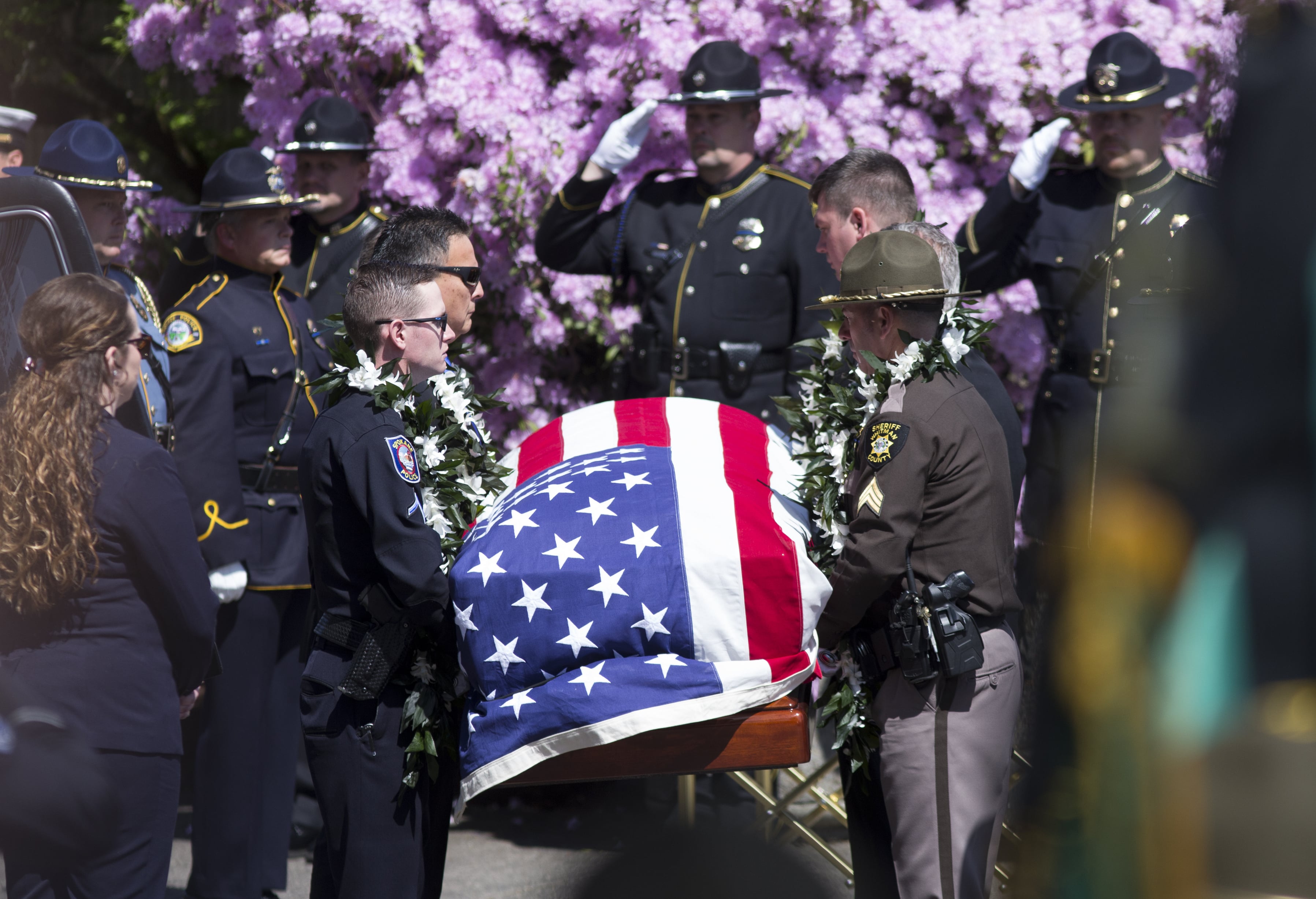 An honor guard carries the casket of Cowlitz County sheriff's Deputy Justin DeRosier as a procession makes its way to the Chiles Center at the University of Portland, where a memorial service is taking place for the slain deputy, Wednesday, April 24, 2019 in Portland, Ore.