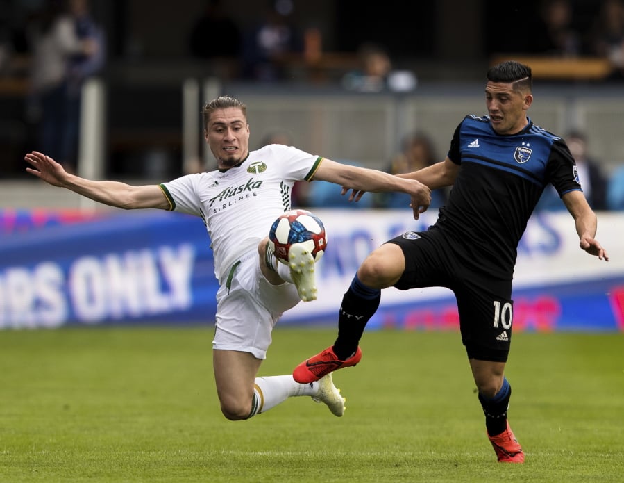 Portland Timbers defender Jorge Villafana, left, and San Jose Earthquakes forward Cristian Espinoza, right, battle for possession in the first half of an MLS soccer match on Saturday, April 6, 2019 in San Jose, Calif.