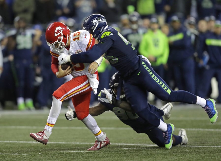 FILE - In this Dec. 23, 2018, file photo, Kansas City Chiefs quarterback Patrick Mahomes (15) is tackled by Seattle Seahawks defensive end Frank Clark, right, during the second half of an NFL football game, in Seattle. The Kansas City Chiefs have agreed to acquire defensive end Frank Clark from the Seattle Seahawks in exchange for a first-round draft pick this year and a second-round pick in 2020. Almost immediately after word leaked of the trade on Tuesday, April 23, 2019, Clark and the Chiefs worked quickly to reach agreement on a five-year contract worth up to $105 million, according to a person with knowledge of the deal. The person spoke to The Associated Press on the condition of anonymity because the deal had not been announced by either team and was still pending a physical.