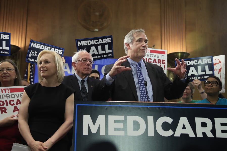 Sen. Jeff Merkley, D-Ore., right, joined by Sen. Bernie Sanders, I-Vt., and Sen . Kirsten Gillibrand, D-N.Y. speaks during a gathering introducing the Medicare for All Act of 2019, on Capitol Hill in Washington, Wednesday, April 10, 2019.