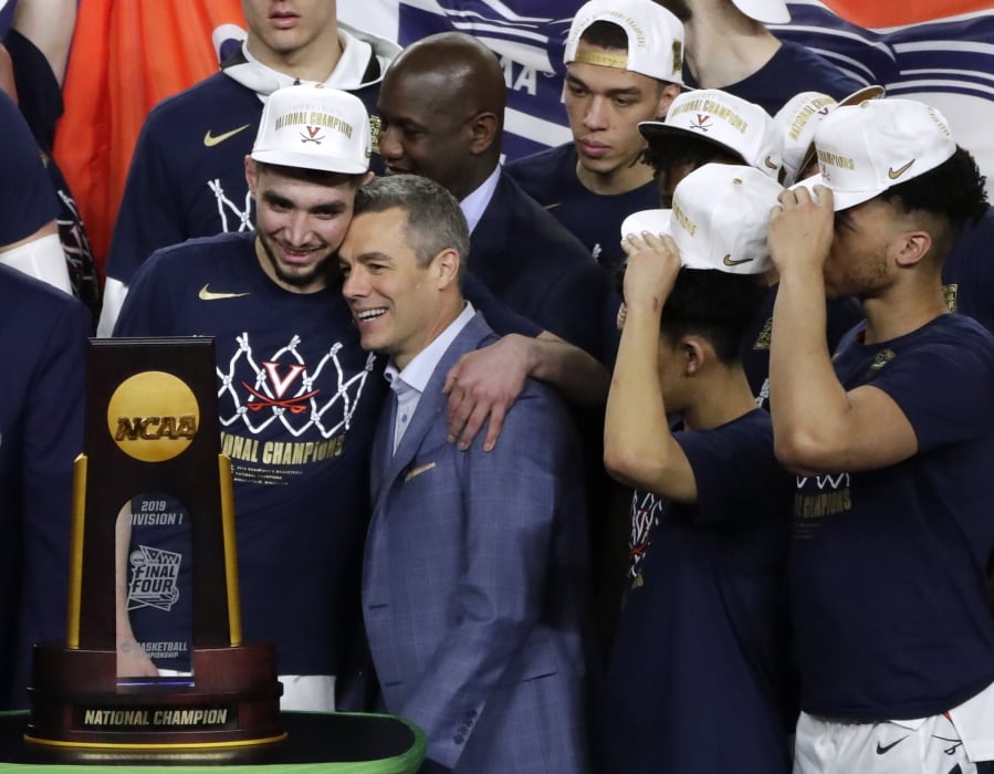 Virginia head coach Tony Bennett, center, celebrates with guard Ty Jerome, left, after the championship game against Texas Tech in the Final Four NCAA college basketball tournament, Monday, April 8, 2019, in Minneapolis. Virginia won 85-77 in overtime.