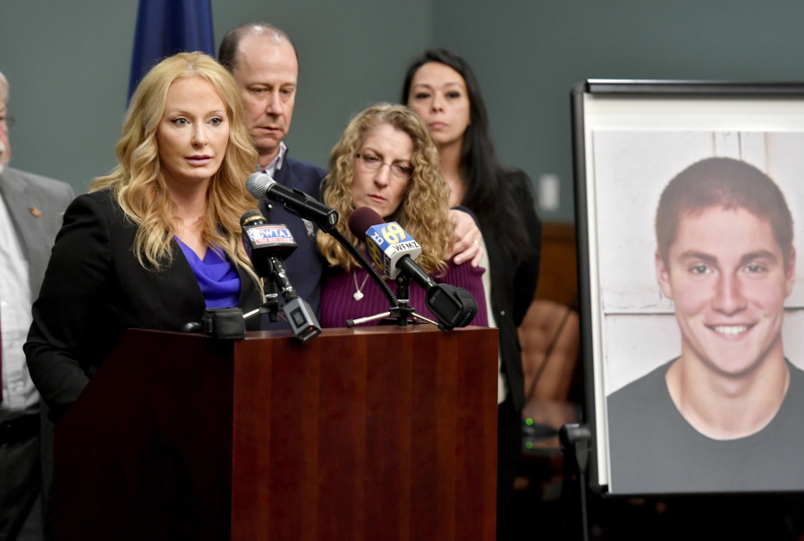 FILE - In this May 5, 2017 file photo, Jim and Evelyn Piazza stand by as Centre County District Attorney Stacy Parks Miller, left, announces the results of an investigation into the death of their son Timothy Piazza, seen in photo at right, a Penn State University fraternity pledge, during a press conference in Bellefonte, Pa. Three ex-Penn State fraternity brothers have been sentenced to jail on hazing charges in connection to the February 2017 death of Piazza. Sentences handed down Tuesday, April 2, 2019, to the three former Beta Theta Pi members range from 30 days to three months in jail.