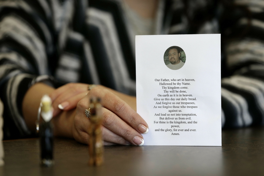 In this photo taken Wednesday, March 6, 2019 in Raleigh, N.C. Heather Allen holds a photo of her father, Lee Wayne Hunt, from his memorial. Even though Lee Wayne Hunt died as a prisoner found guilty of a double murder, his family says he never gave up hope of proving his innocence.