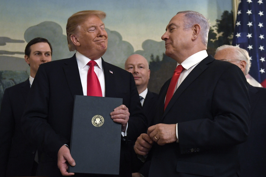 FILE - In this Monday, March 25, 2019 file photo, President Donald Trump smiles at Israeli Prime Minister Benjamin Netanyahu, right, after signing a proclamation in the Diplomatic Reception Room at the White House in Washington.