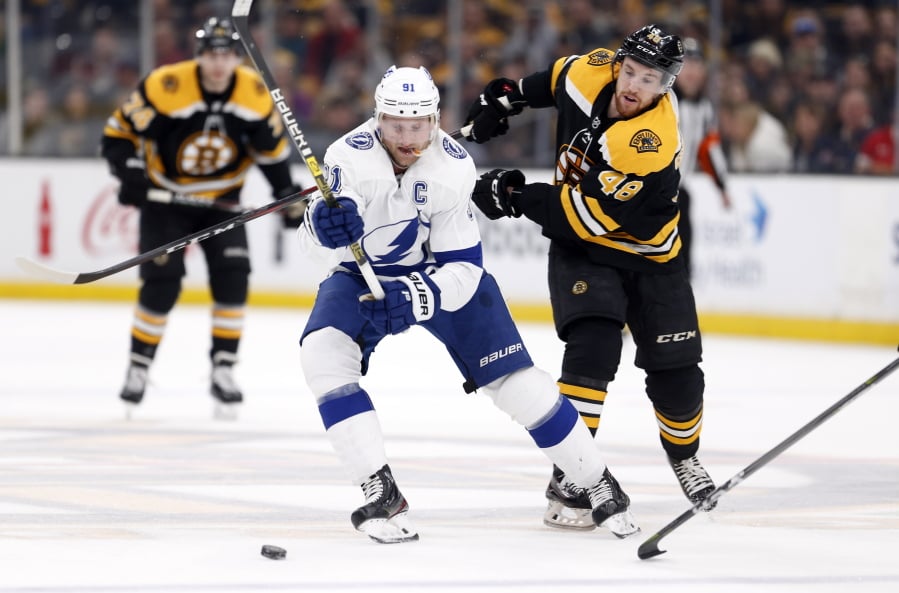 Tampa Bay Lightning’s Steven Stamkos (91) and Boston Bruins’ Matt Grzelcyk (48) battle for the puck during the first period of an NHL hockey game in Boston, Saturday, April 6, 2019.