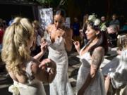 Models wearing wedding dresses get ready to smoke marijuana during the Cannabis Wedding Expo in Los Angeles in January.