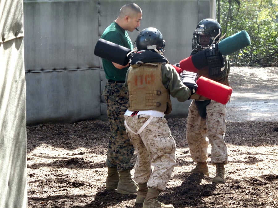 In this Feb. 21, 2013, file photo, female recruits battle with pugil sticks during training at the Marine Corps Training Depot on Parris Island, S.C. The Marine Corps’ brief experiment integrating female recruits into an all-male unit for their initial training at boot camp has come to an end.