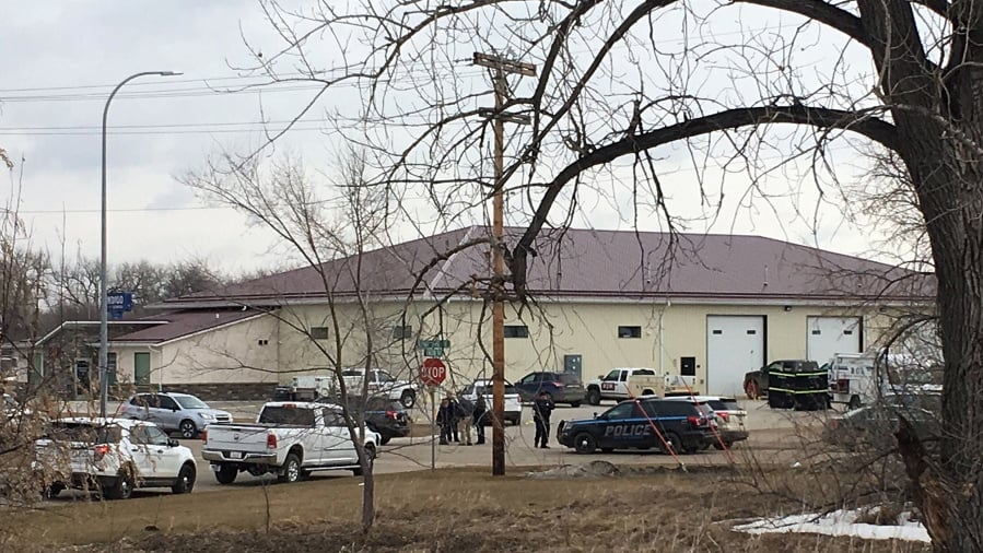 Police vehicles are seen in the backside of RJR Maintenance and Management, a property management company, Monday, April 1, 2019, Mandan, N.D. Authorities say police responding to a medical call at the North Dakota business have found “several” bodies. The Mandan Police Department issued a three-sentence news release confirming that officers had found “several people who were deceased inside” the business in the city of about 22,000 just across the Missouri River west of Bismarck.