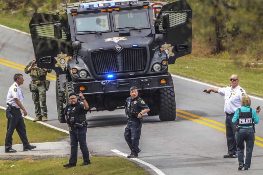 Clayton County police officers work a scene where a gunman reportedly shot a few Henry County police officers in Stockbridge, Ga., Thursday, April 4, 2019. A gunman suspected of shooting two Georgia police officers remain barricaded in a home Thursday with a teenager who was considered a hostage, police said.