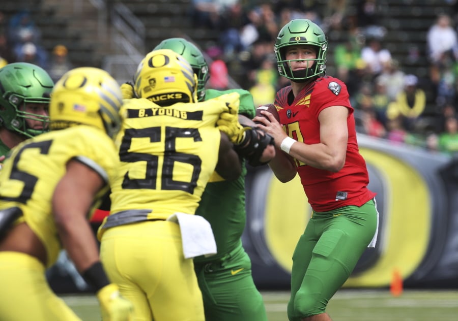 Oregon’s Justin Herbert, right, looks downfield on a pass play during an NCAA college spring football game.