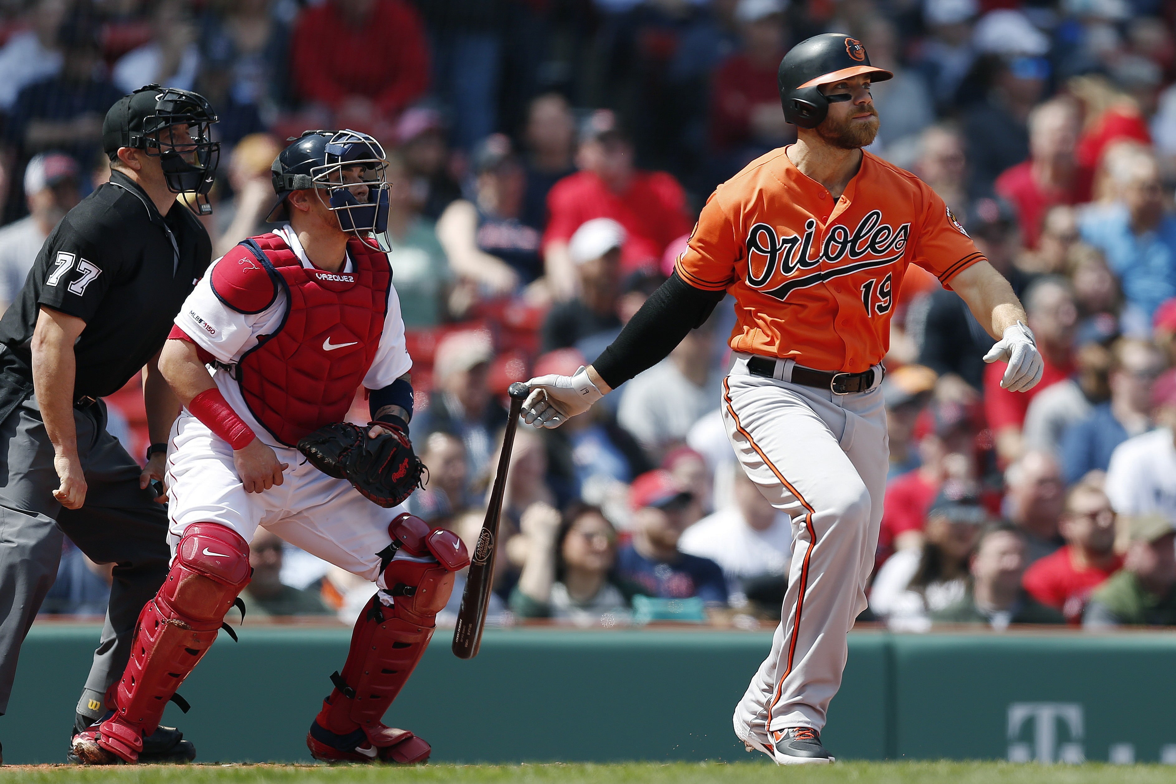 Baltimore Orioles' Chris Davis watches his two-run single in front of Boston Red Sox's Christian Vazquez during the first inning of a baseball game in Boston, Saturday, April 13, 2019.