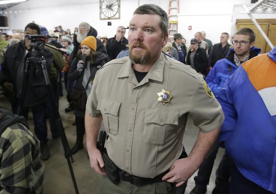 FILE - In this Jan. 6, 2016, file photo, Harney County Sheriff David Ward arrives at a community meeting at the Harney County fairgrounds in Burns, Ore. Ward says he will resign at the end of 2019 because his department is underfunded and he’s concerned about liability from unlawful jail conditions.