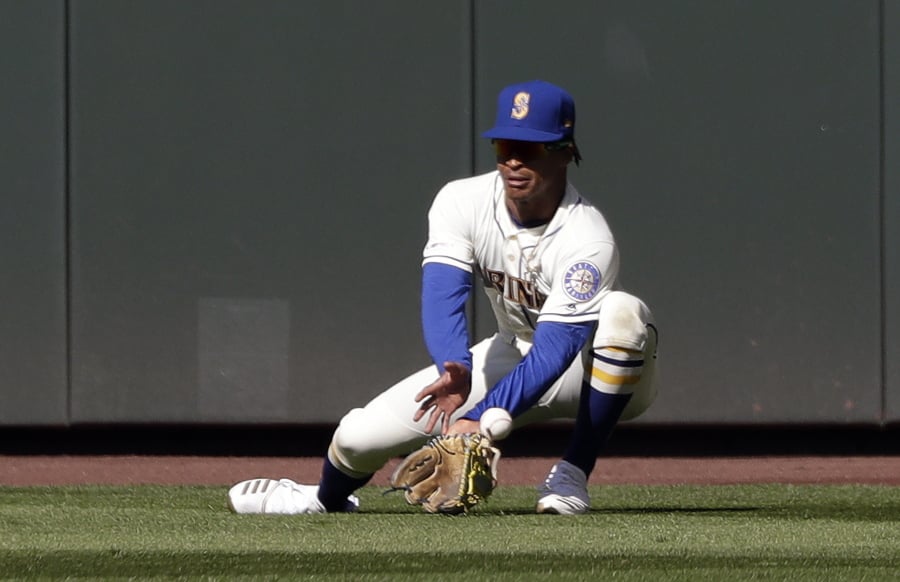 Seattle Mariners center fielder Mallex Smith misplays a fly ball from Texas Rangers’ Elvis Andrus for an error in the ninth inning of a baseball game Sunday, April 28, 2019, in Seattle.