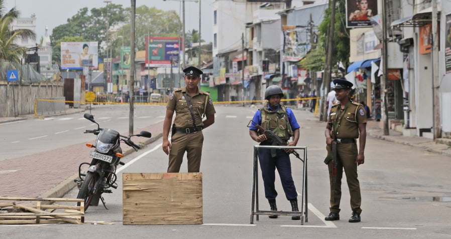 Sri Lankan policemen and a Naval soldier stand guard at a Check point in Colombo, Sri Lanka, Monday, April 29, 2019. The Catholic Church in Sri Lanka says the government should crack down on Islamic extremists with more vigor “as if on war footing” in the aftermath of the Easter bombings.