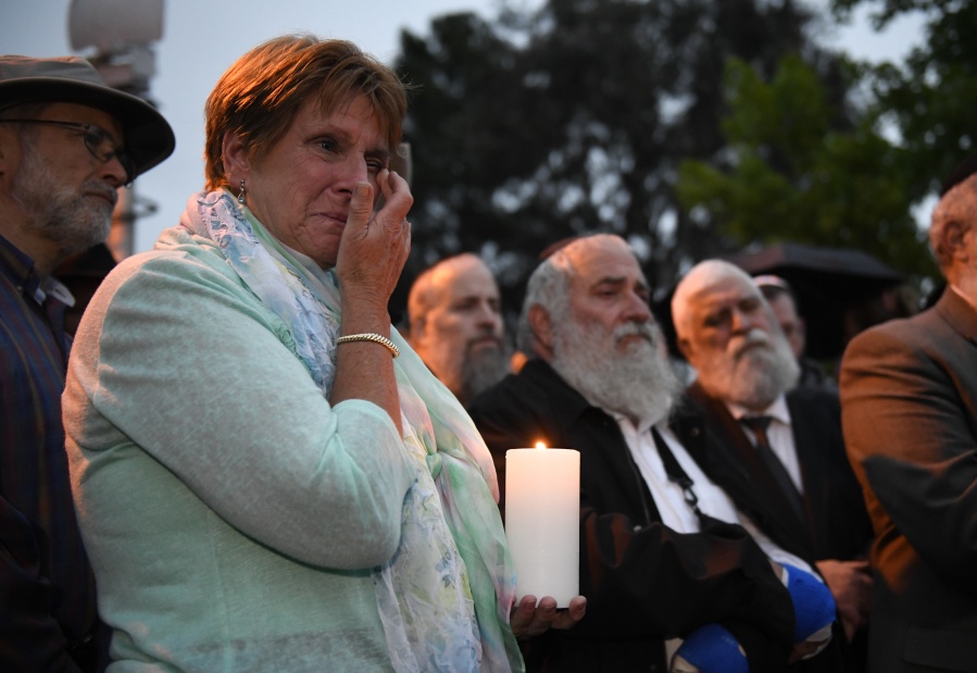 A woman cries during a candlelight vigil held for victims of the Chabad of Poway synagogue shooting, Sunday, April 28, 2019, in Poway, Calif. A man opened fire Saturday inside the synagogue near San Diego as worshippers celebrated the last day of a major Jewish holiday.