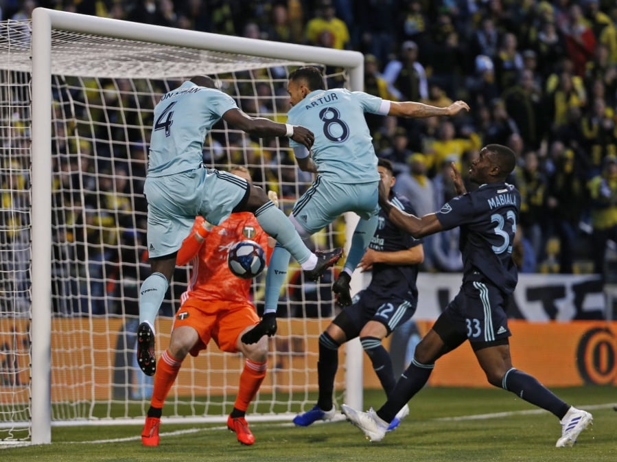 Columbus Crew defender Jonathan Mensah (4) and midfielder Artur (8) are unable to score against Portland Timbers goalkeeper Jeff Attinella (1) and defender Larrys Mabiala (33) in the first half of an MLS soccer game in Columbus, Ohio, Saturday, April 20, 2019.