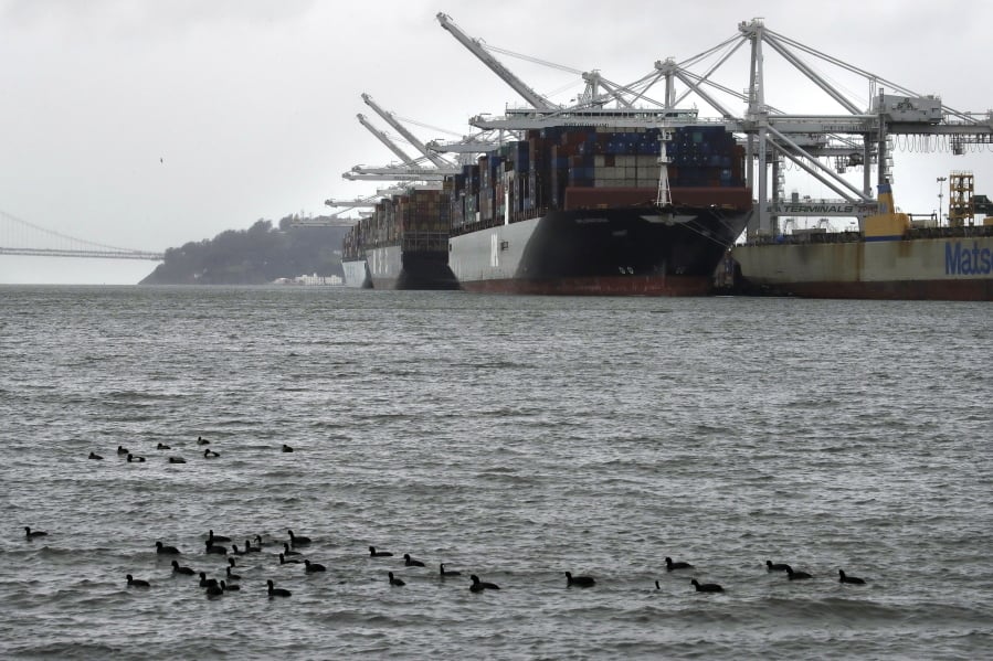 Container ships docked at the Port of Oakland wait to be unloaded on March 6 in Oakland, Calif.