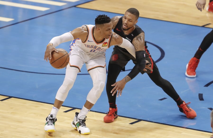 Oklahoma City Thunder guard Russell Westbrook (0) drives to the basket as Portland Trail Blazers guard Damian Lillard (0) defends in the first half of Game 4 of an NBA basketball first-round playoff series Sunday, April 21, 2019, in Oklahoma City.