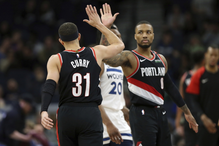 Portland Trail Blazers’ Seth Curry (31) high-fives teammate Damian Lillard in the second half of an NBA basketball game against the Minnesota Timberwolves, Monday April 1, 2019, in Minneapolis.