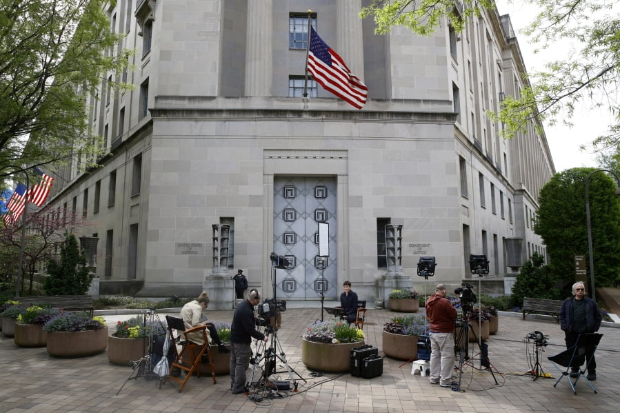 Television news crews are set up outside the Department of Justice building Wednesday in Washington.