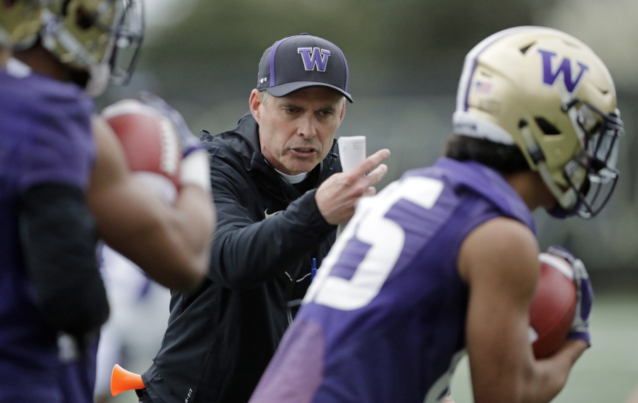 Washington head coach Chris Petersen talks to players as they run drill during the first day of spring NCAA college football practice, Wednesday, April 3, 2019, in Seattle. (AP Photo/Ted S.