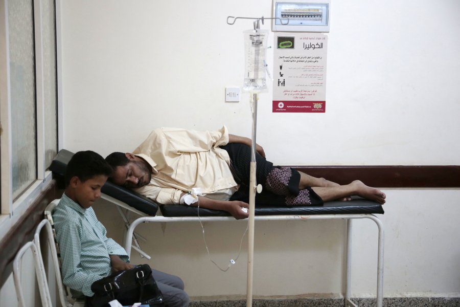 FILE - In this July 1, 2017 file photo, a man is treated for suspected cholera infection at a hospital in Sanaa, Yemen. An Associated Press investigation finds that Yemen’s massive cholera epidemic was aggravated by corruption and official intransigence. The investigation has found that both the Iranian-backed Houthis rebels and their main adversary in the war -- the U.S.- and Saudi-backed government that controls southern Yemen -- impeded efforts by relief groups to stem the epidemic.
