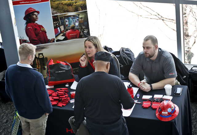 In this March 7, 2019, file photo visitors to the Pittsburgh veterans job fair meet with recruiters at Heinz Field in Pittsburgh. On Friday, April 5, the U.S. government issues the March jobs report.