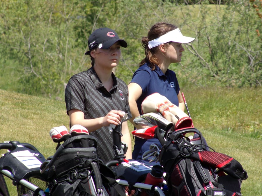 Camas’ Emma Cox (left) stands with Skyview’s Maddy Startwalt between shots at the 4A district girls golf tournament (Tim Martinez/The Columbian)