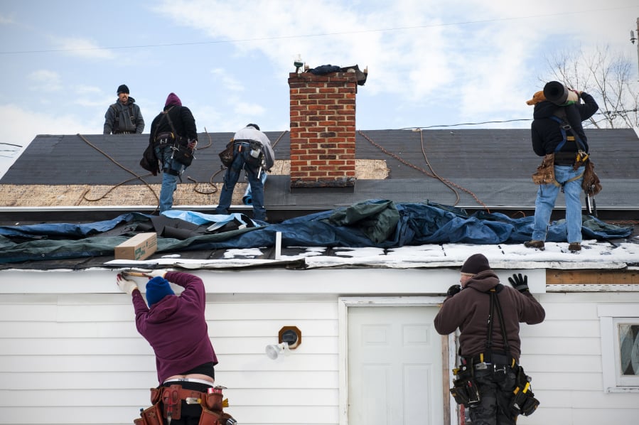 Workers replace a roof in Leesburg, Va.