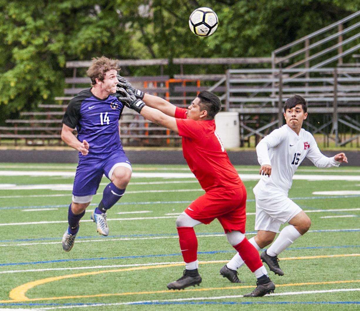 Columbia River's Jake Connop, left, heads in the Chieftains' second goal over Franklin Pierce goalkeeper Oscar Rosas and defender Brandon Hernandez in a 2A State quarterfinal Saturday at Chieftain Stadium. Columbia River won 4-1.