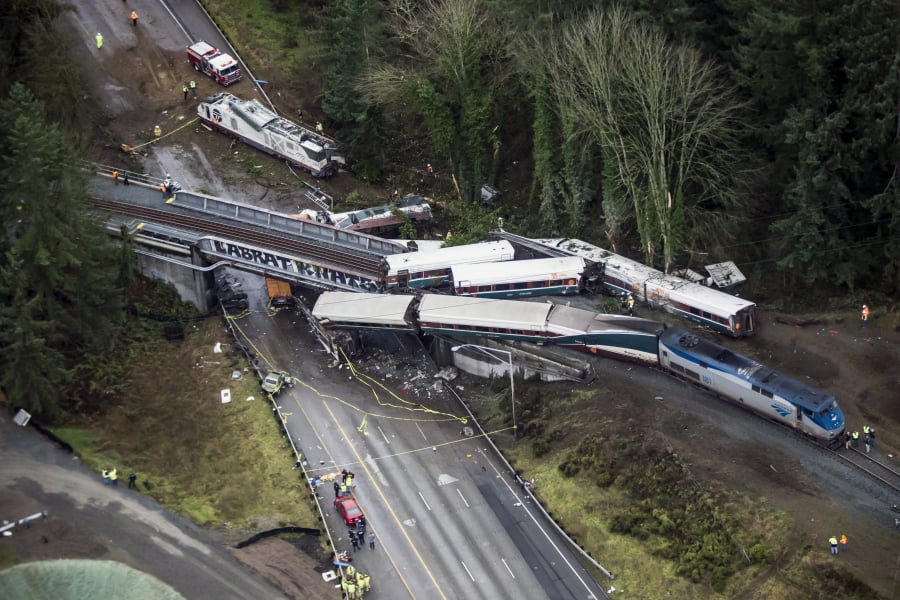 Cars from an Amtrak train that derailed are piled along and onto Interstate 5 near DuPont on Dec. 18, 2017. Three people were killed.
