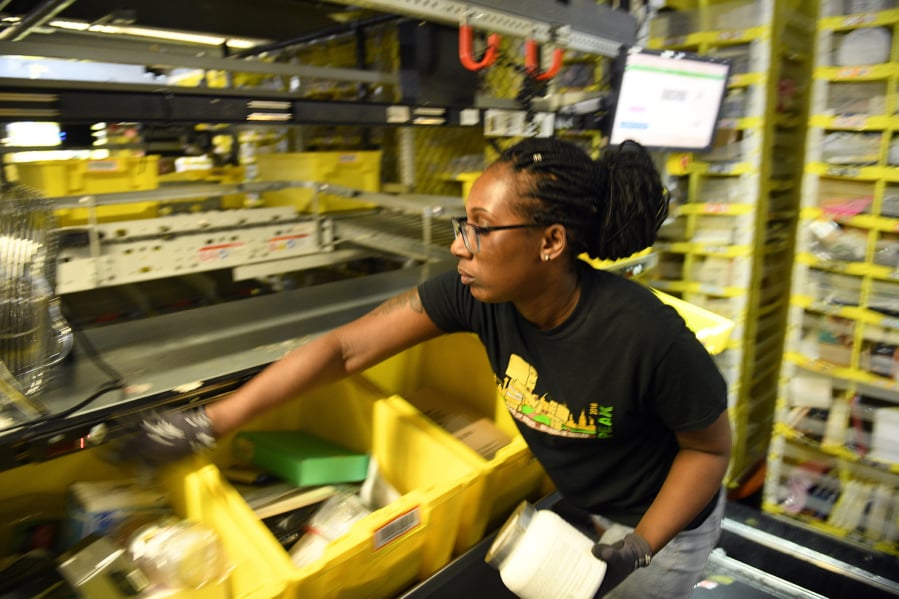 Jackie Spence places products into bins in the Amazon’s fulfillment center in Baltimore.