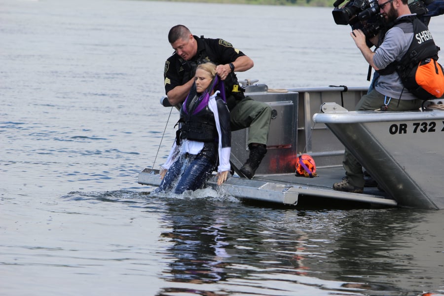 A sheriffs officer pulls Ashley Massey of the Oregon Marine Board from the Columbia River. She had taken the plunge during a demonstration of cold water and how quickly someone can become hypothermic in cool late-spring waters in the region.