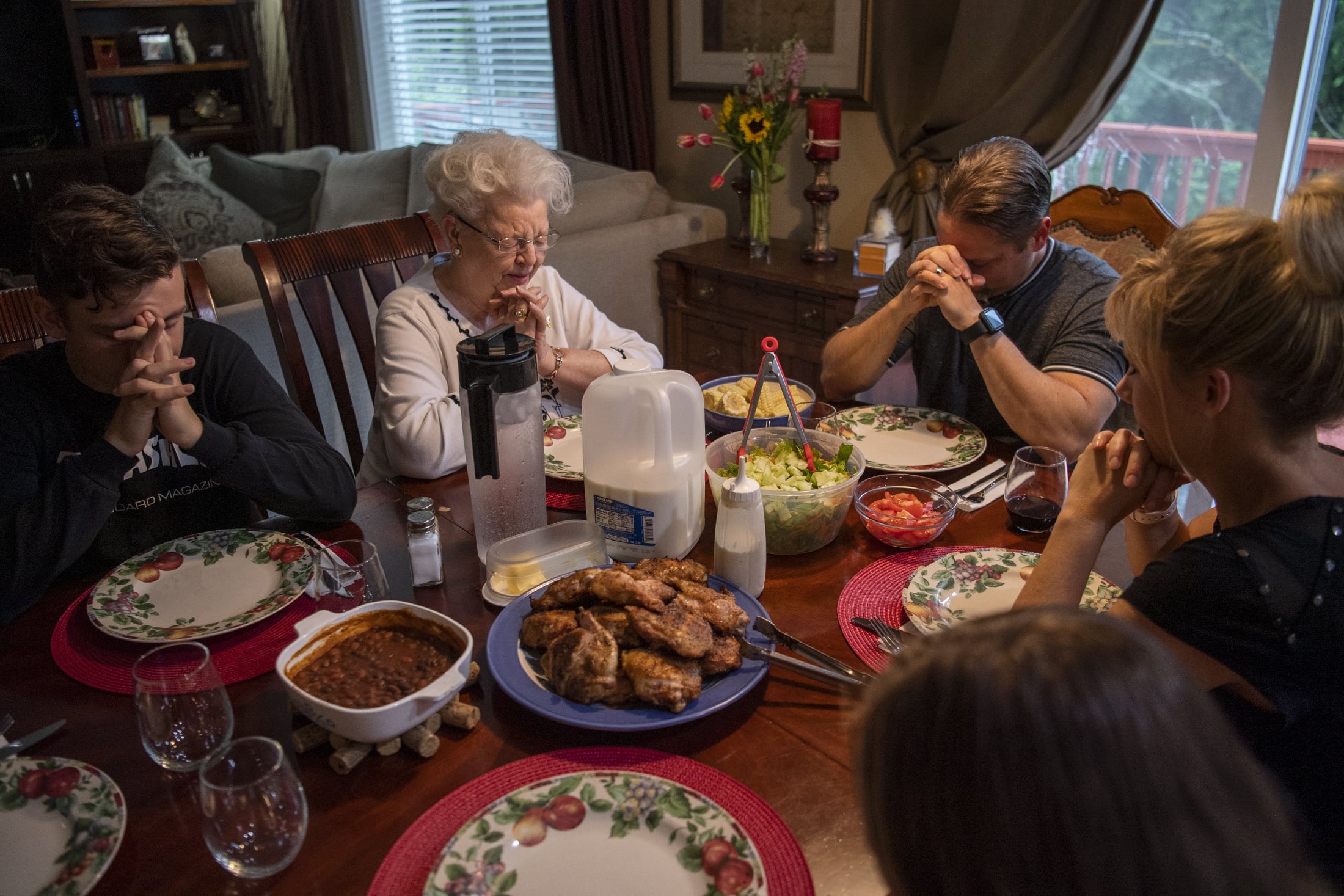 Vivian Church, center, leads a prayer with her grandson, Hal Stokes, right, and his family before dinner at their home in Ridgefield on Friday, May 17, 2019. Church moved in to the finished basement at her grandsonÕs home in 2015. Aside from a full kitchen, she has a whole living area to herself.