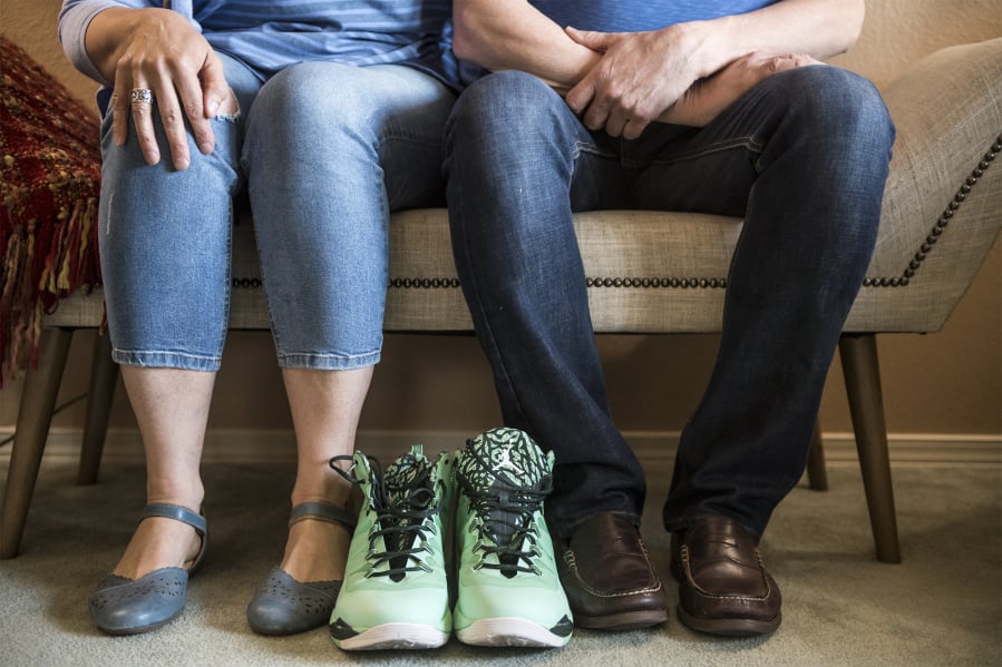 Beth and John Moritz sit with their son’s basketball sneakers. At 6-feet, 10-inches, Zach Moritz was always known for being tall, but shied away from the attention his height garnered.