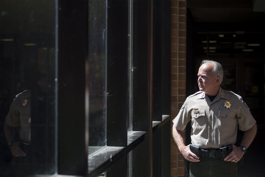 Clark County Sheriff Chuck Atkins takes a peek outside his office Monday afternoon. The sheriff recently sat down with The Columbian to reflect on his first term.