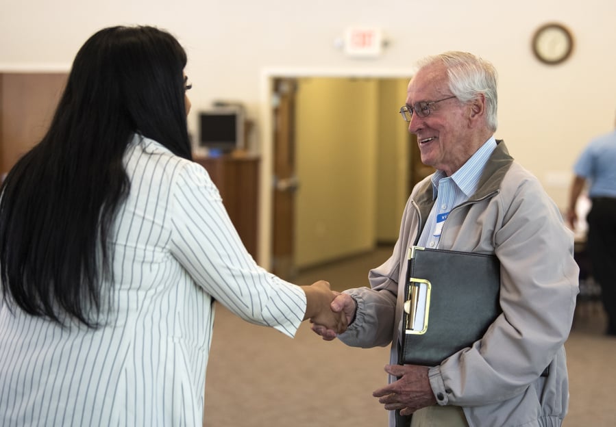 Aerotek recruiter Krti Hariharan, left, talks with Lew Olsen of Vancouver during a hiring event for job seekers in the 50-and-older age group hosted by Goodwill Industries on Wednesday.
