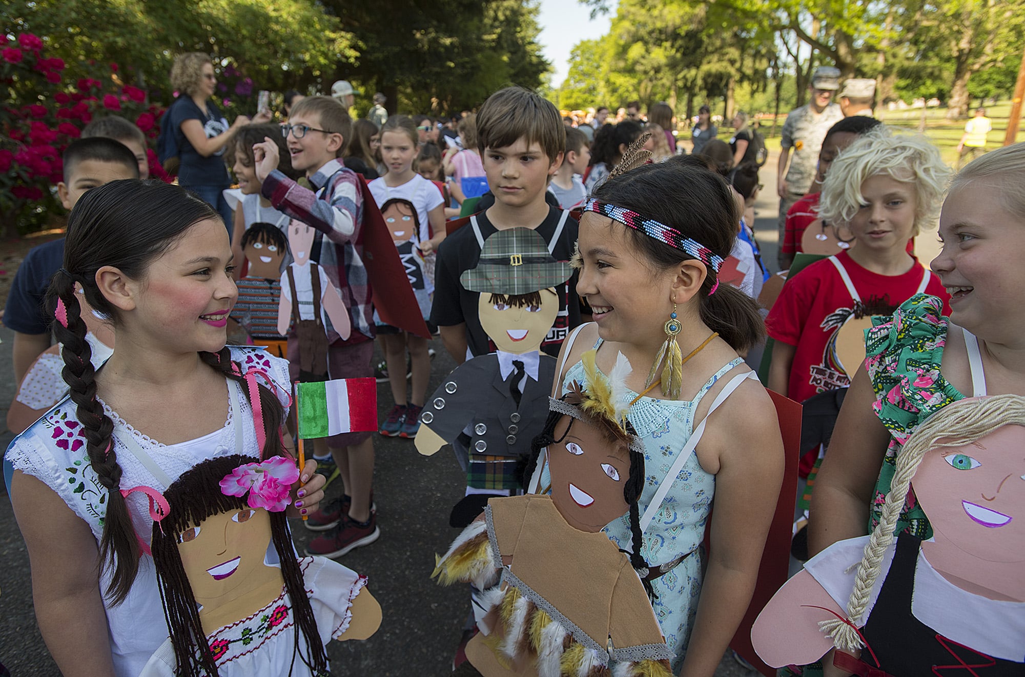 Lake Shore Elementary School third-graders Heaven Rodriguez, with braids, who was representing Mexico, joins classmate Isabella Lester, both 9, who was representing Native Americans, as they wait for the annual Children's Cultural Parade to begin at Fort Vancouver National Historic Site on Friday morning, May 10, 2019. Over 1,500 third grade students celebrated learning, community and diversity as they marched through the parade route and ended at the stockade with a speech by Gov. Jay Inslee.