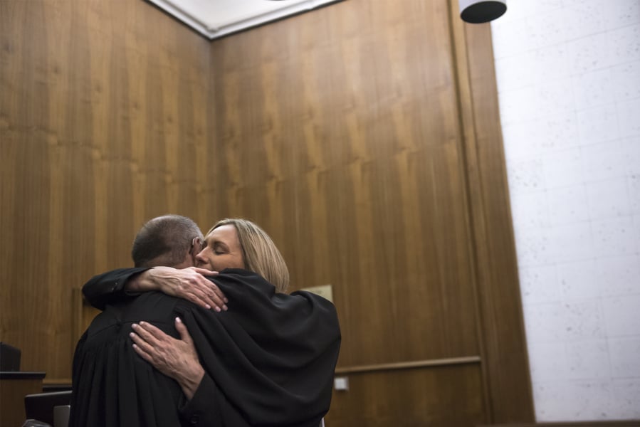 Washington Court of Appeals Judge Rich Melnick, left, hugs Judge Jennifer Snider following her swearing-in ceremony Thursday at the Clark County Courthouse.